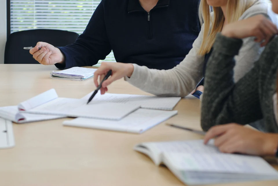 Colleagues working through papers at a meeting table
